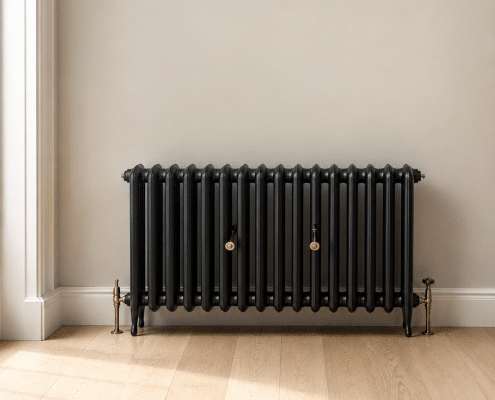 Black column radiator installed in a bright room with wooden flooring
